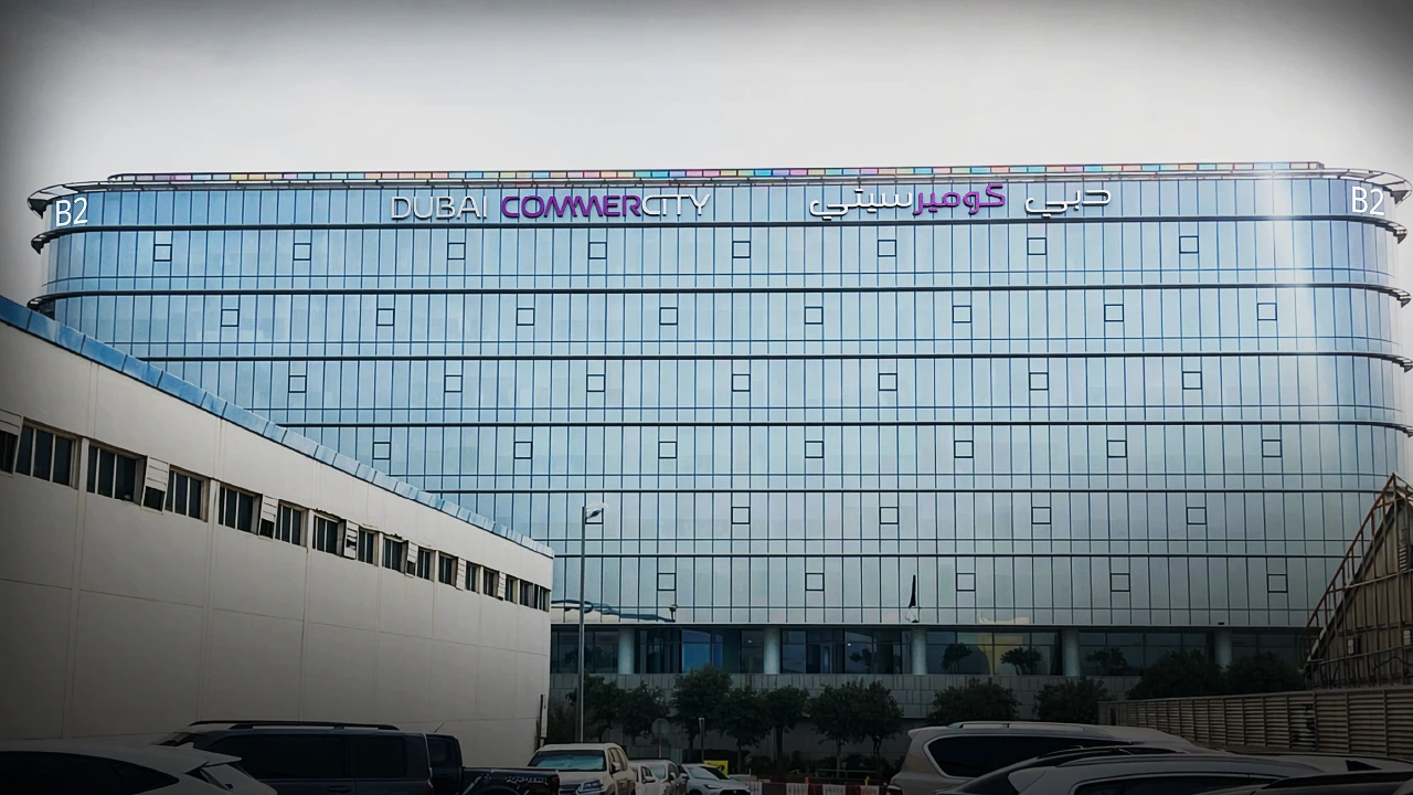Dubai CommerCity glazed office building by day with the project logotype at roof level