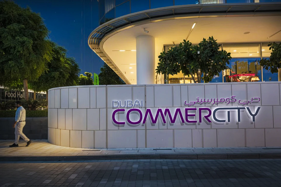 Dubai CommerCity identity wall with the project logotype in English and Arabic